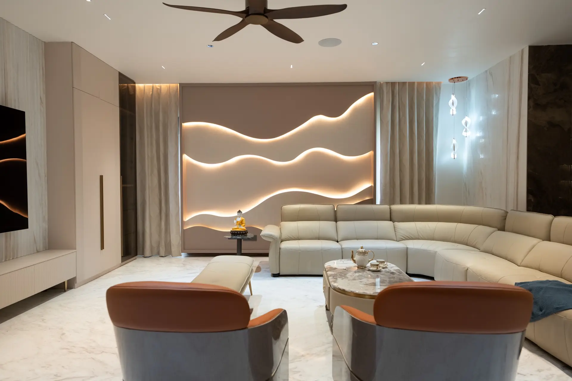 Living room with a backlit wave feature wall and cream sectional, designed by Simplify Home, Hyderabad
